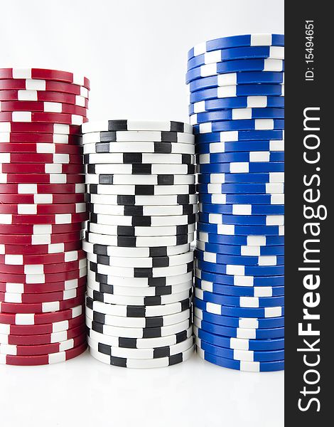 Red, white & blue poker chips on white background.