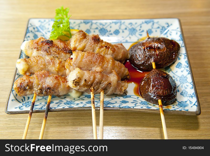A plate of delicious and skewered chicken, pork and mushroom, coated with cheese, wrapped and barbecued, then served in a Japanese restaurant, a fine delicacy here in the local food scene. A plate of delicious and skewered chicken, pork and mushroom, coated with cheese, wrapped and barbecued, then served in a Japanese restaurant, a fine delicacy here in the local food scene.