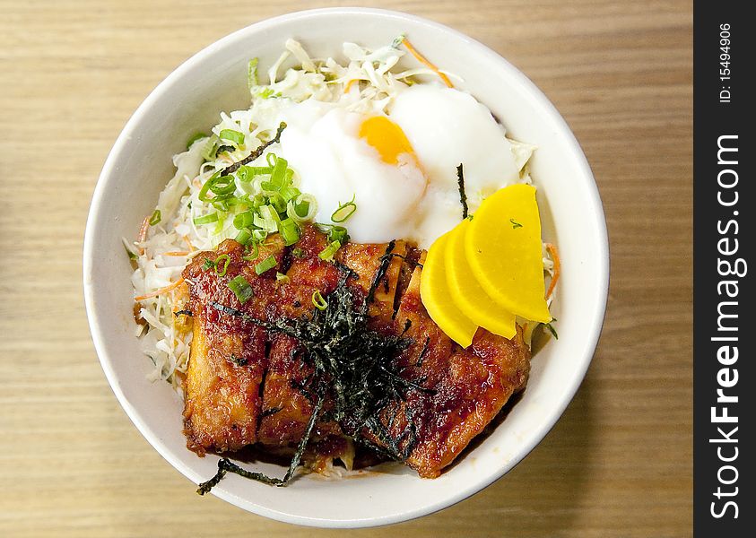 Japanese style braised rice (don) together with a piece of well glazed teriyaki chicken, finished with a half-boiled egg and vegetables garnishing. Japanese style braised rice (don) together with a piece of well glazed teriyaki chicken, finished with a half-boiled egg and vegetables garnishing.