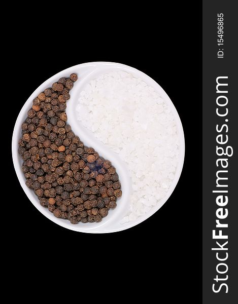 Black pepper and salt on a black background