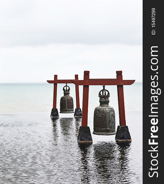 Two old large bells in water pool with sea-view