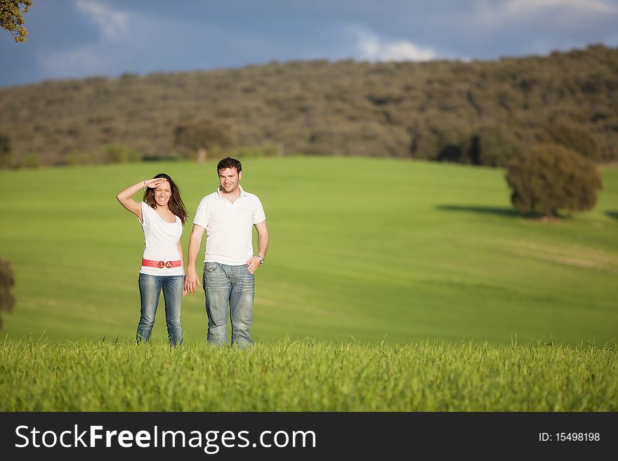 Young beautiful couple hand by hand isolated on natural green background. Young beautiful couple hand by hand isolated on natural green background.
