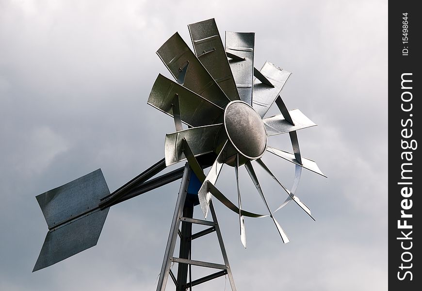 Reproduction of an aluminum windmill against an overcast sky
