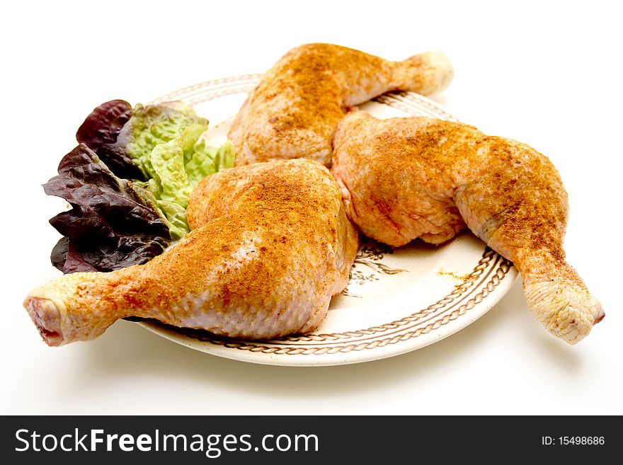 Raw chickens thighs seasoned with lettuce leaf