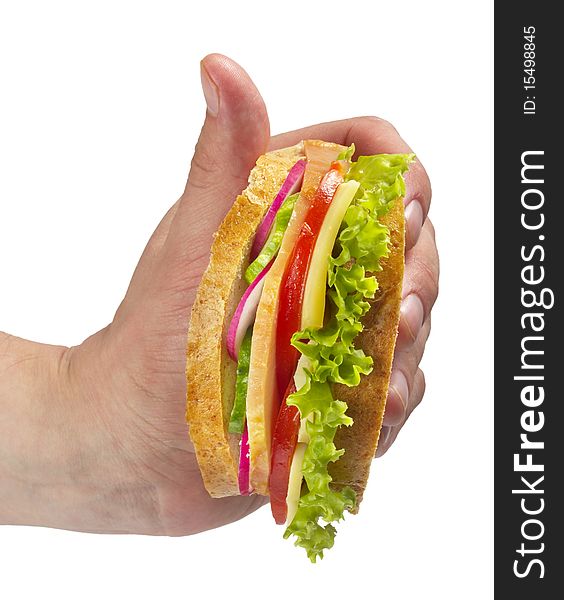 Sandwich with ham, tomato, radish, cucumber and cheese in the hand isolated over white background. Sandwich with ham, tomato, radish, cucumber and cheese in the hand isolated over white background