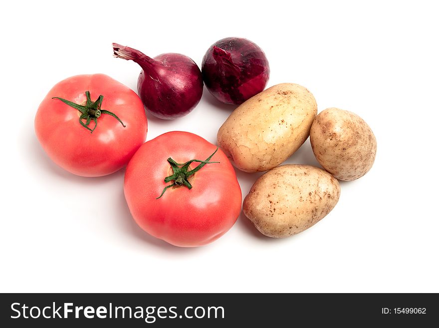 Collection of vegetables: potatoes, tomatoes and onions, shot on a white background