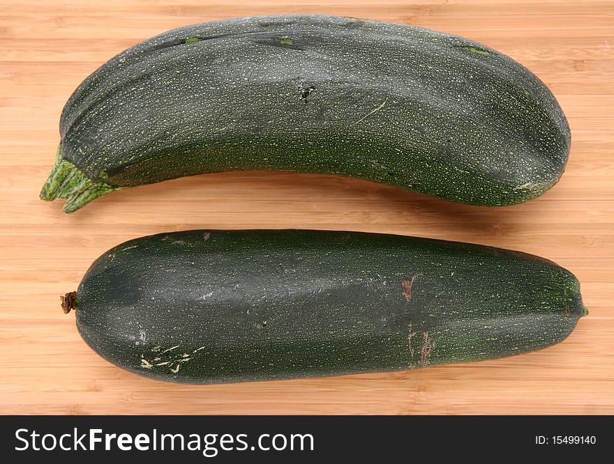 Two zucchinis on a chopping board on white background