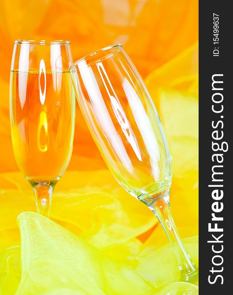 Two champagne glasses in front of orange background