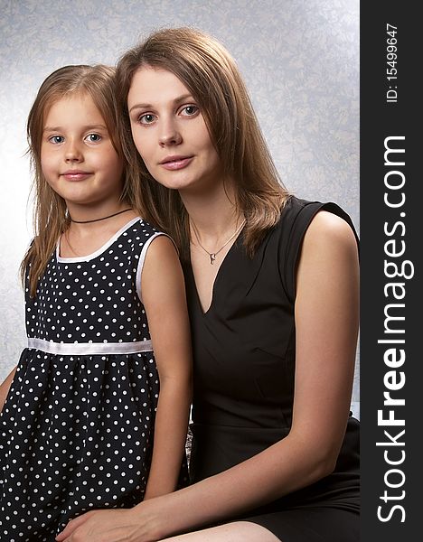 Mother and daughter portrait over light defocused background