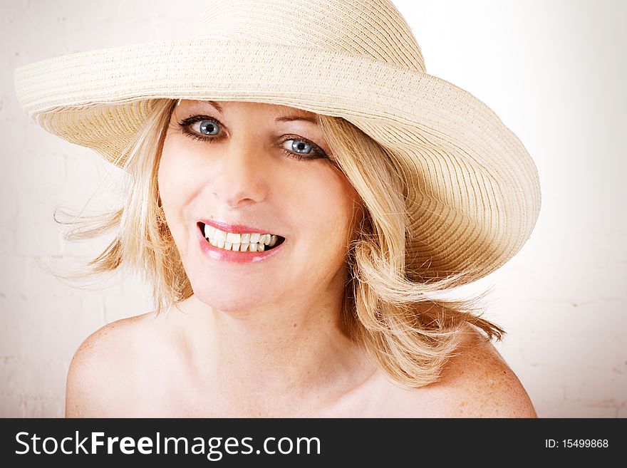 Beautiful middle aged woman wearing a sun hat and smiling. Beautiful middle aged woman wearing a sun hat and smiling.