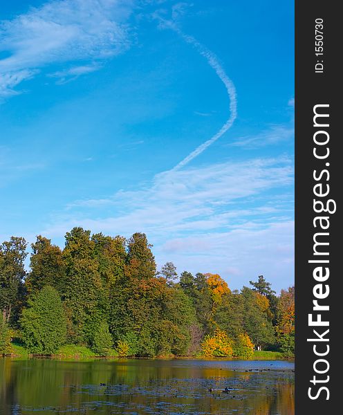 Autumn wood around of lake in a sunny day and the sky with clouds. Autumn wood around of lake in a sunny day and the sky with clouds