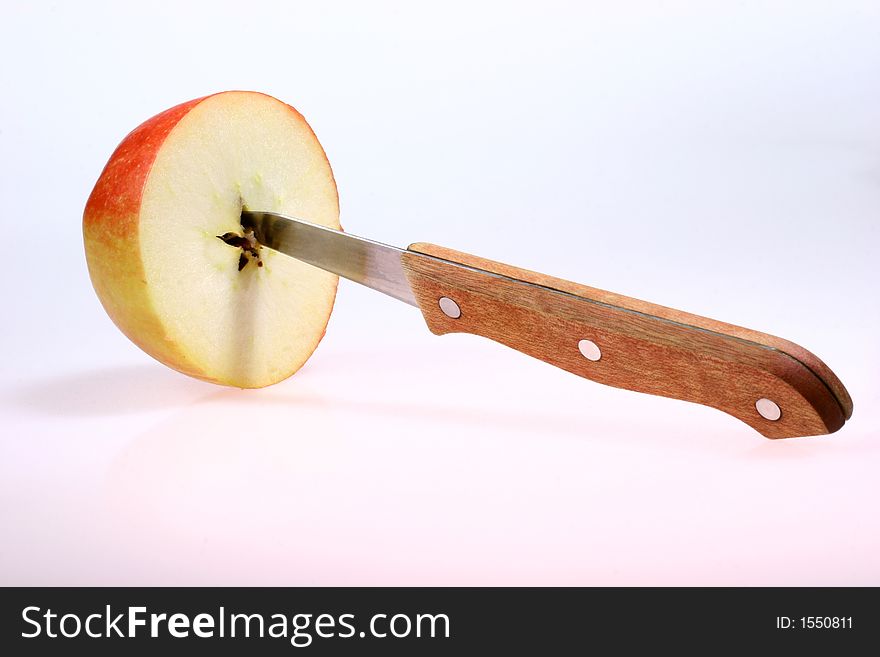 Half a red apple with knife isolated on white. Half a red apple with knife isolated on white