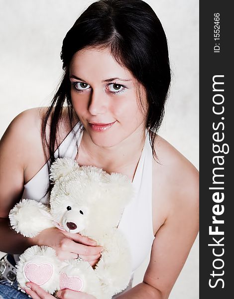 Young brunette woman with white teddy bear. Young brunette woman with white teddy bear
