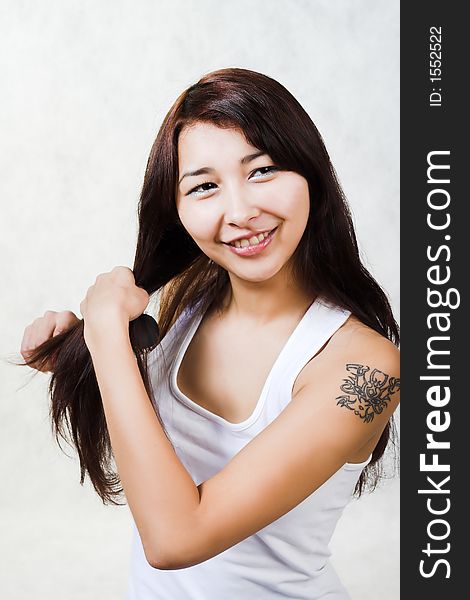 Pretty asian woman with hairbruch. Friendly Smile.