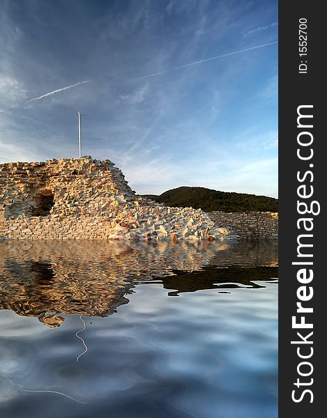 Stone wall with reflection in water