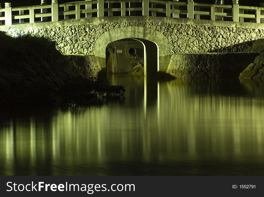 A walking bridge shot during low light condition to show reflection in water. A walking bridge shot during low light condition to show reflection in water