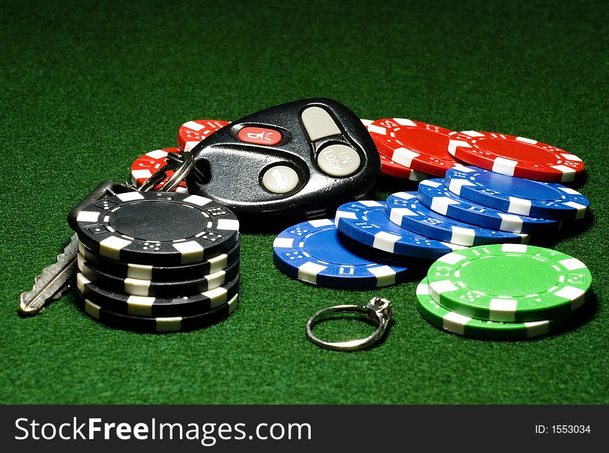 Poker chips in pot on poker table, including car keys and diamond ring. Poker chips in pot on poker table, including car keys and diamond ring.