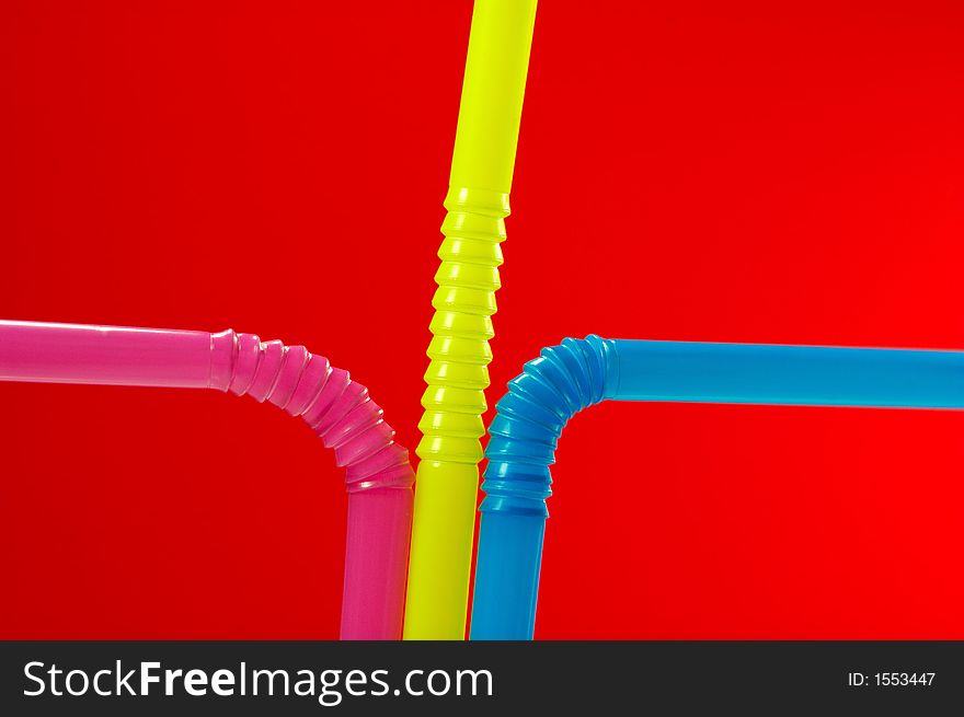 Red Background with close-up of multi colored drinking straw
