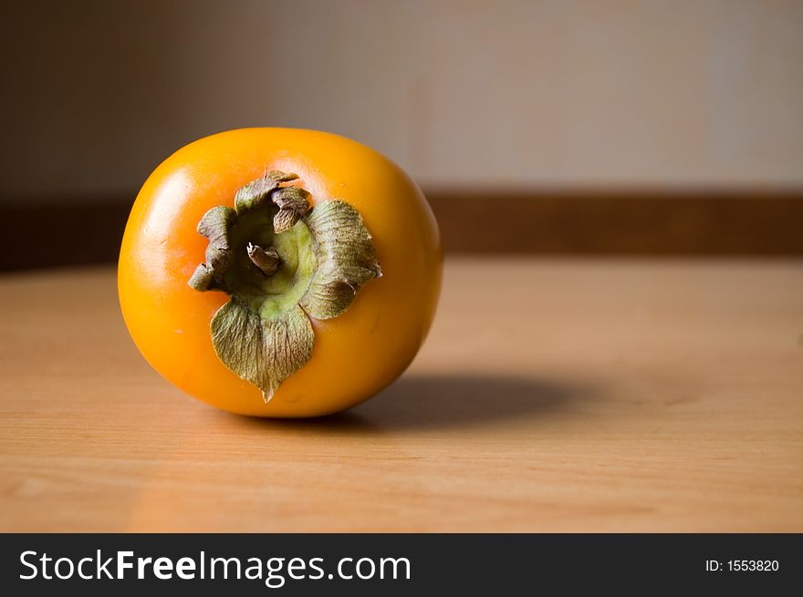 Picture of a sweet persimmon on a wooden table