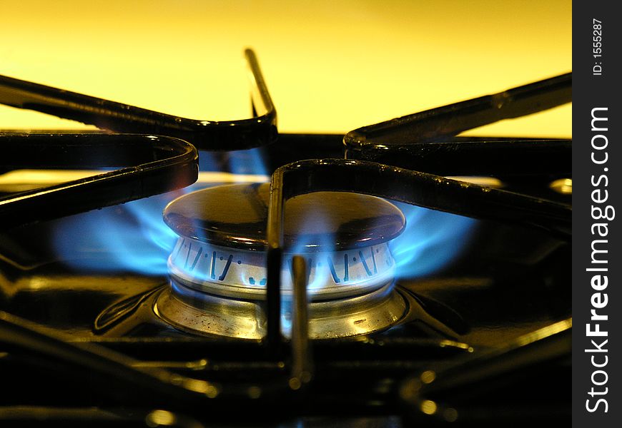 Bright blue flame of a stove burner with yellow background. Bright blue flame of a stove burner with yellow background.