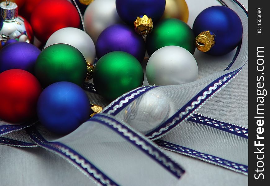 Various colored Xmas ornaments against a snowy background. Various colored Xmas ornaments against a snowy background