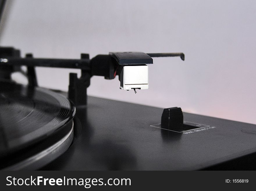 Turntable and a vinyl disc ready to play.The focus is on the disc and on the needle. Turntable and a vinyl disc ready to play.The focus is on the disc and on the needle