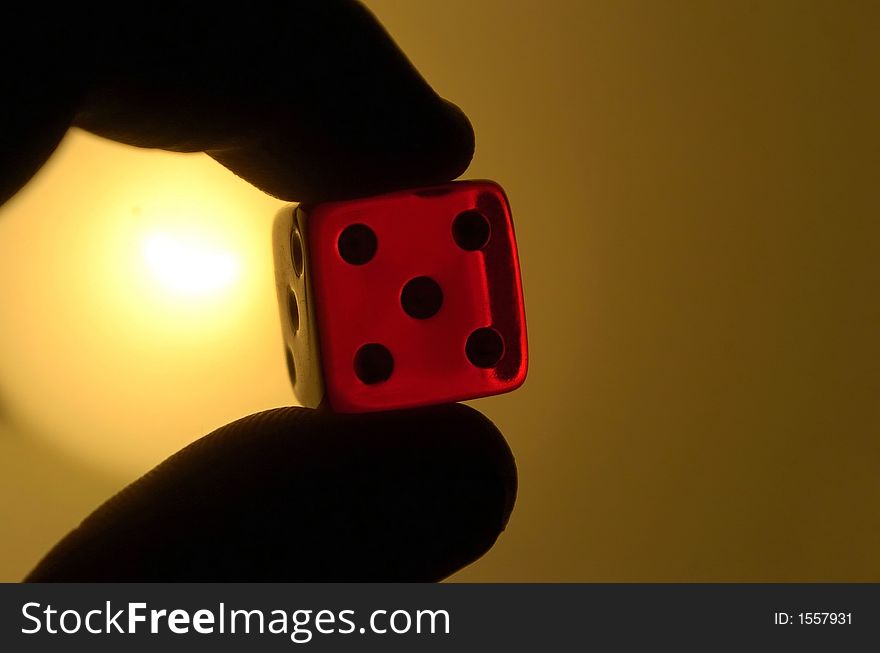 Dice held in hand with five spot showing. Dice held in hand with five spot showing