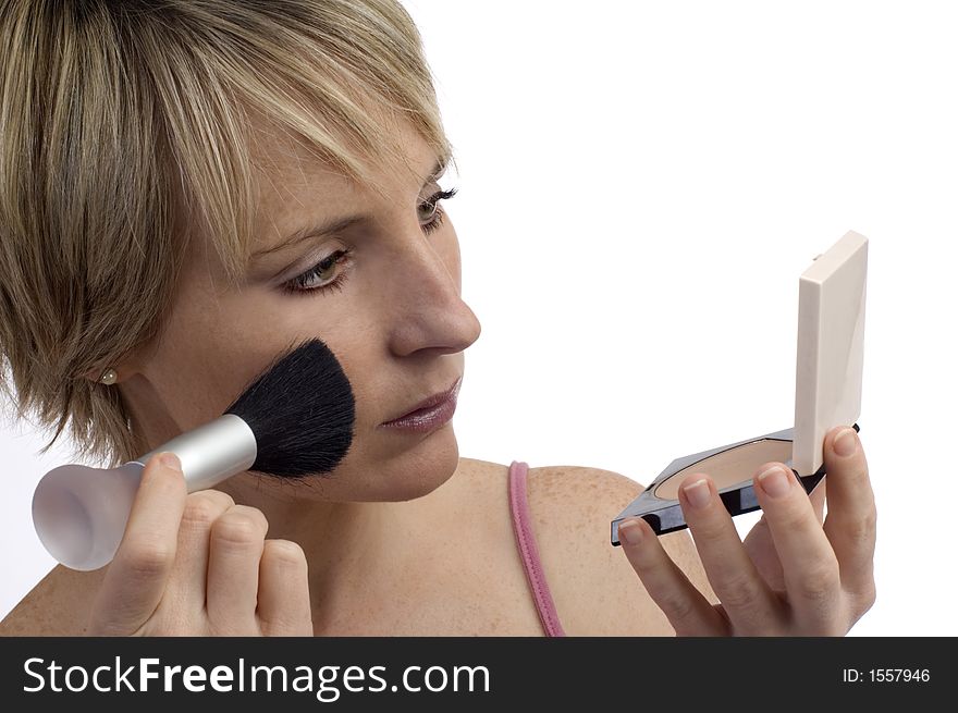 A young woman touches up her makeup. A young woman touches up her makeup