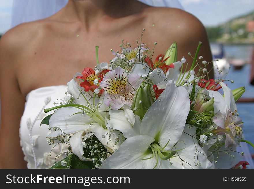 Young pretty bride with bouquet of lilies. Soft-focused, focus on the flowers. Young pretty bride with bouquet of lilies. Soft-focused, focus on the flowers