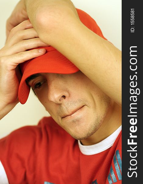 A young man with a red hat looking down. A young man with a red hat looking down
