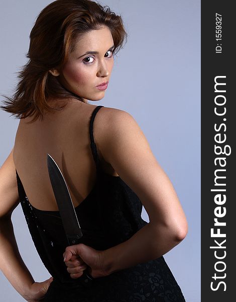 Woman hiding large knife behind her back ready for kill. Woman hiding large knife behind her back ready for kill.