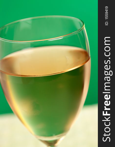 Glass of wine on green background