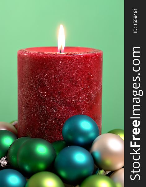 Burning candle surrounded by small ornaments. Burning candle surrounded by small ornaments