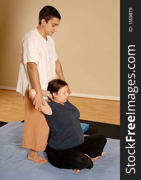 Man stretching woman client in massage thai