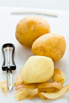 Potatoes And A Peeler Stock Photo