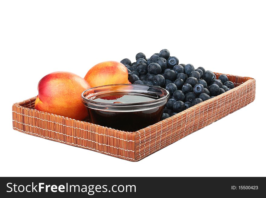 Peach, honey and blueberry in a wooden wattled tray.
