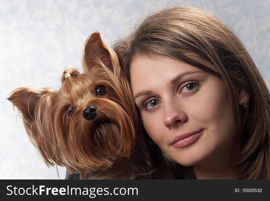 Young woman with her Yorkshire terrier portrait over light defocused background. Young woman with her Yorkshire terrier portrait over light defocused background