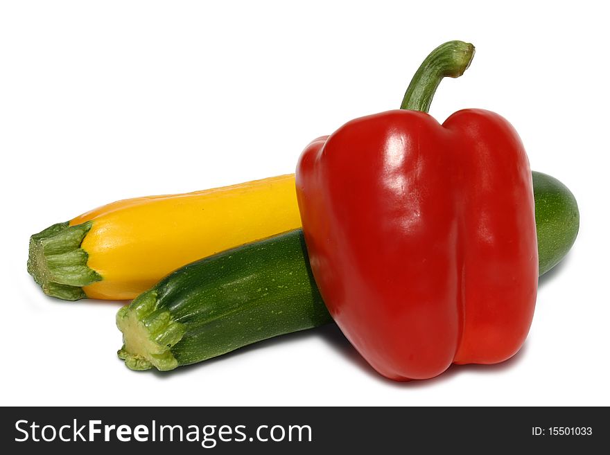 Red pepper and green and yellow zucchini isolated against white. Red pepper and green and yellow zucchini isolated against white.