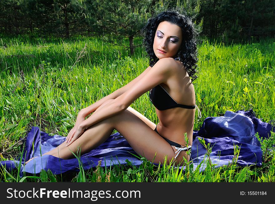 Young beautiful woman wearing black bikini sunbathing