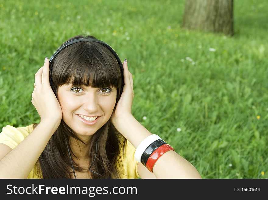 Smiling young woman listening to music at park