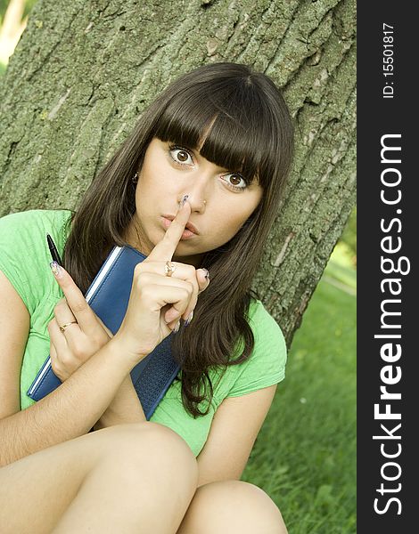 Young beautiful woman in a park with a notebook. Young beautiful woman in a park with a notebook.