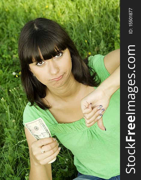 Young woman outdoors holding a cash. Thinks. Little money. Young woman outdoors holding a cash. Thinks. Little money