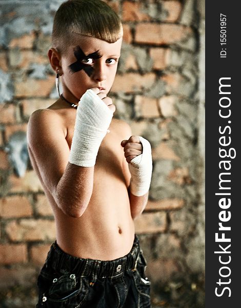 Little kick-boxing boy on grange backgorund. Little kick-boxing boy on grange backgorund