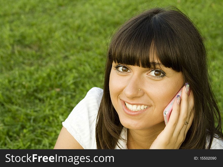 Young beautiful woman on the phone in the park. Young beautiful woman on the phone in the park.