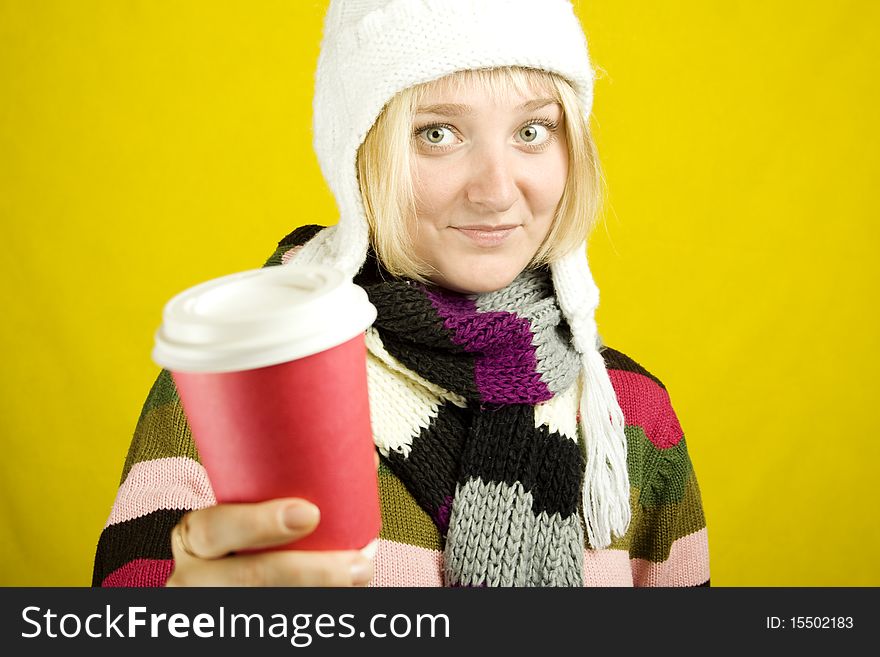 Young woman in a warm sweater, scarf and hat holding a paper cup of coffee. Winter. Young woman in a warm sweater, scarf and hat holding a paper cup of coffee. Winter