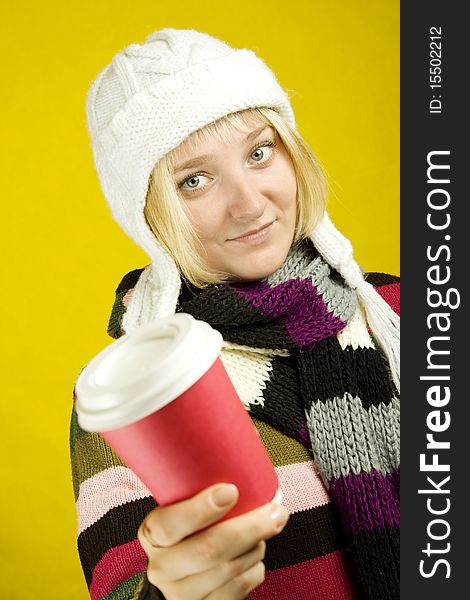 Young woman in a warm sweater, scarf and hat holding a paper cup of coffee. Winter. Young woman in a warm sweater, scarf and hat holding a paper cup of coffee. Winter