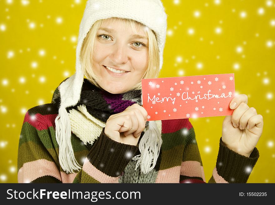 Young woman holds the card with the text Merry Christmas
