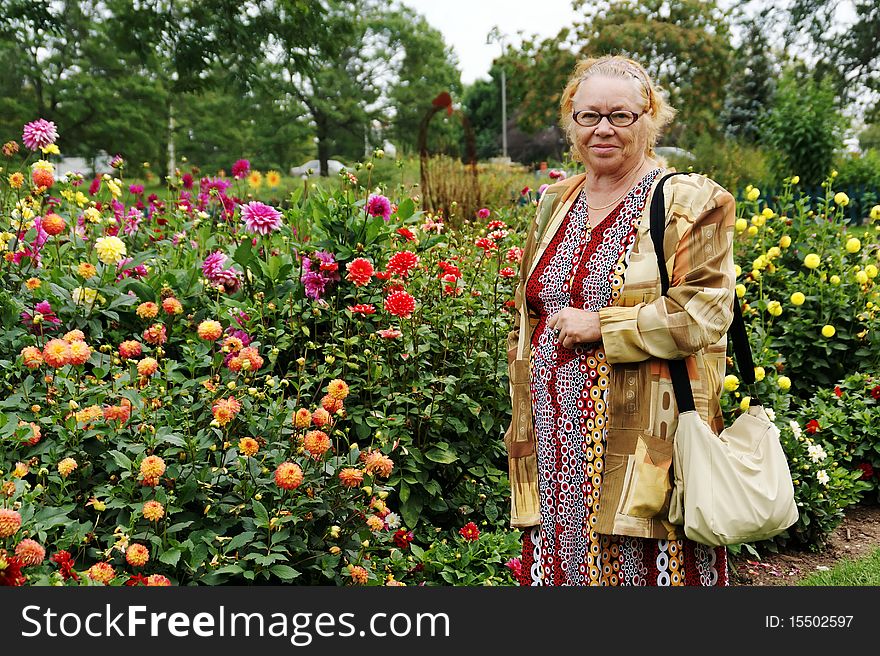 Smiling older lady in blooming garden. Smiling older lady in blooming garden