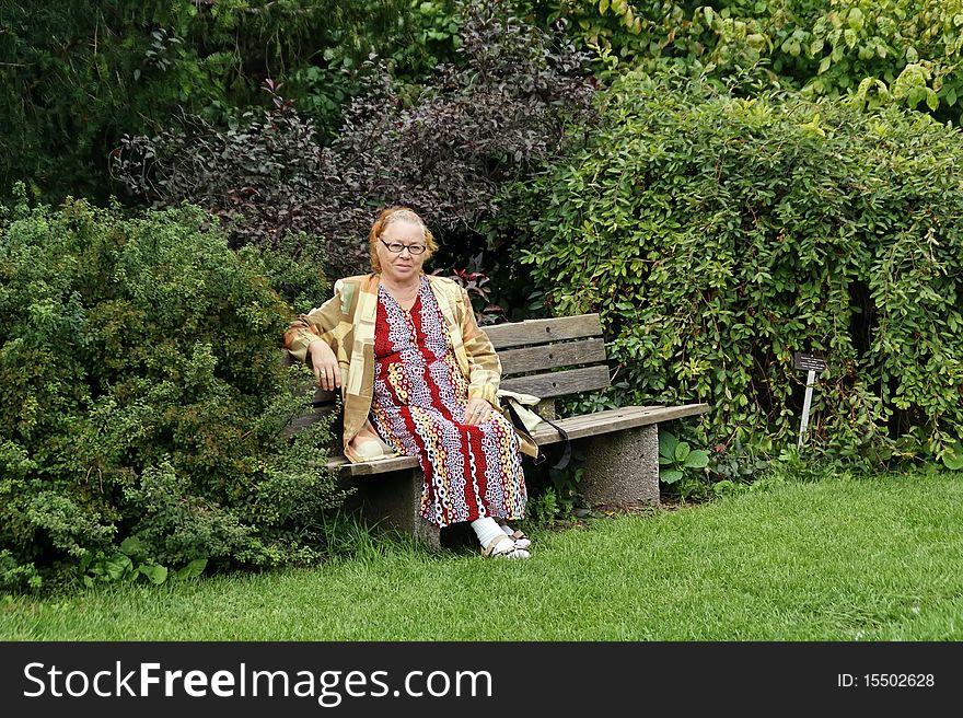 Older lady relaxing in green garden. Older lady relaxing in green garden