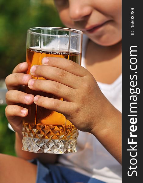 Child hands holding glass of apple juice. Child hands holding glass of apple juice